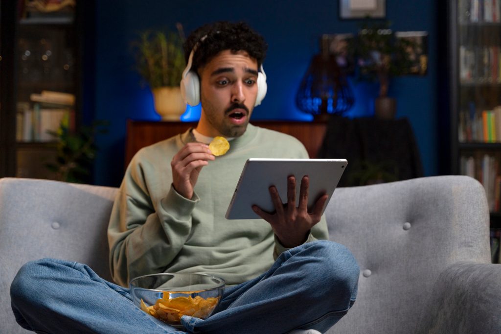 Do you have to pay for streaming – young man enjoying movie night on sofa answering the question 'Do you have to pay for streaming